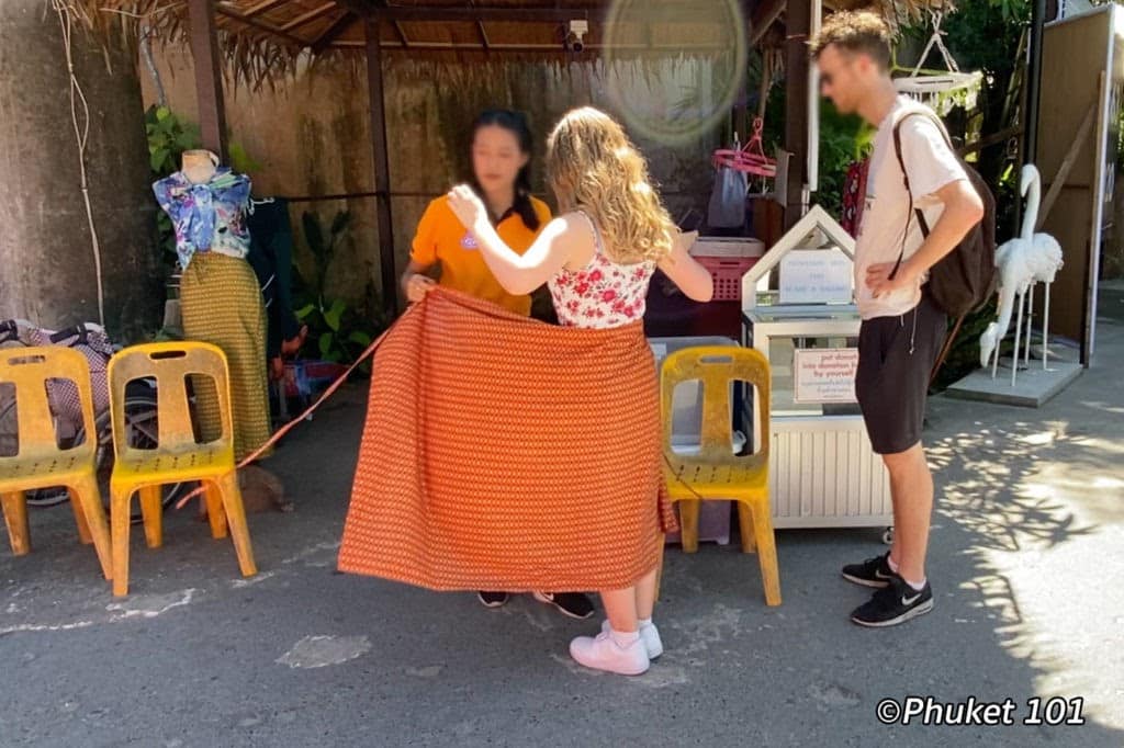 A woman being offered a Sarong at the entrance of Big Buddha, Phuket