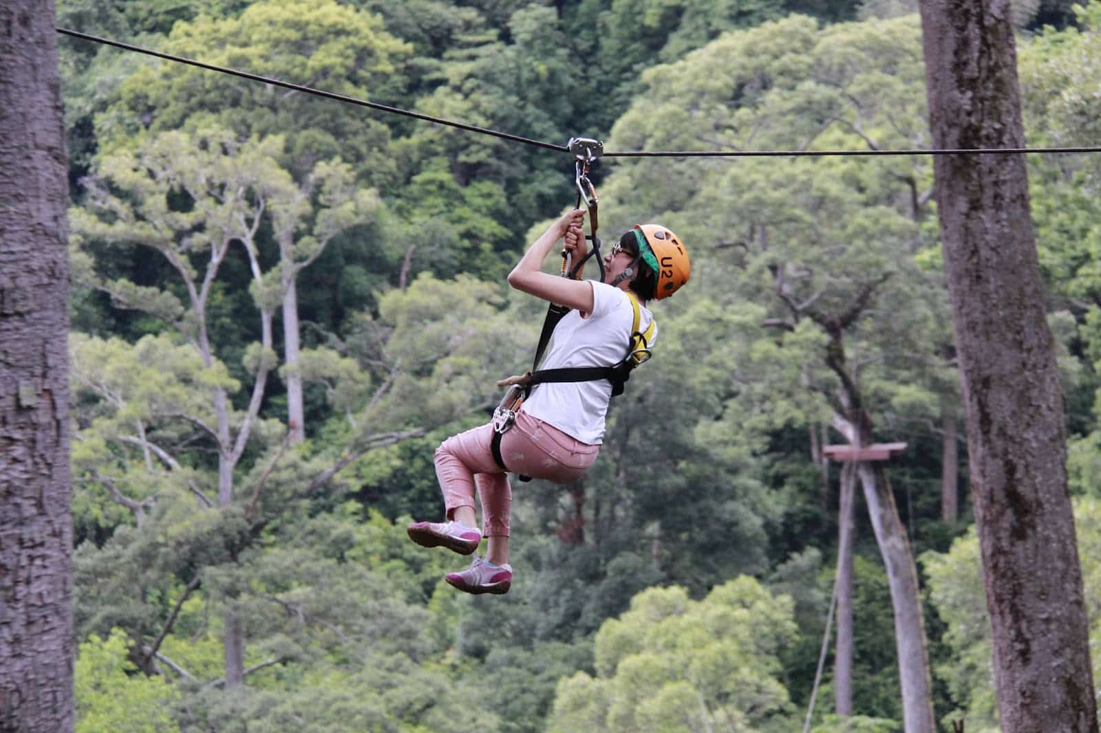 An elderly woman ziplining at Jungle Flight
