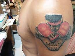 A Muscular Man Flaunting His “Muay Thai” Tattoo at Cool Point Tattoo Club