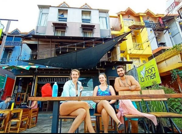 Guests seated outside Non-La Mer Hostel in Koh Lanta