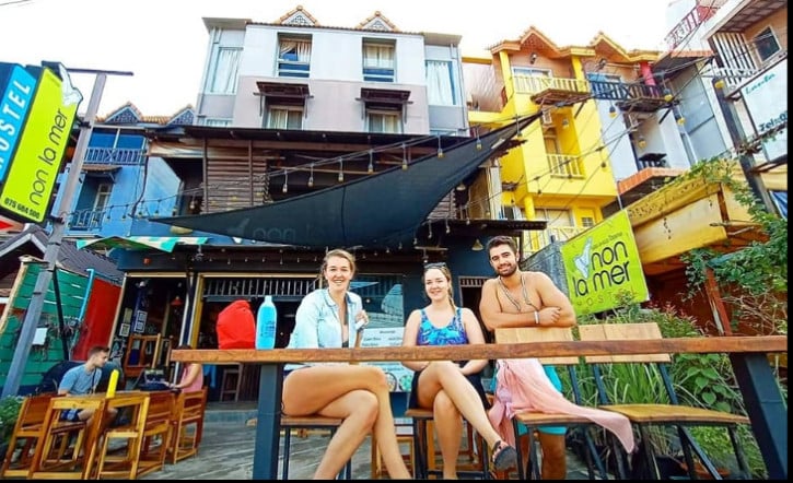 Guests seated outside Non-La Mer Hostel in Koh Lanta