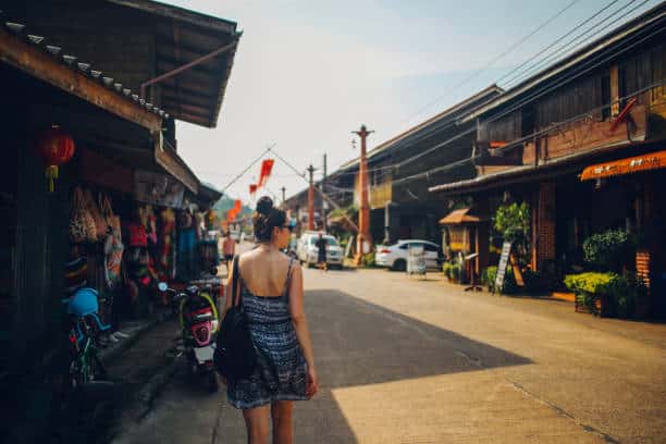 Vintage toned image of a young tourist woman, traveling solo, walking on the streets of the Koh Lanta Old Town, in Thailand. The best Season for Koh Lanta, Old Town
