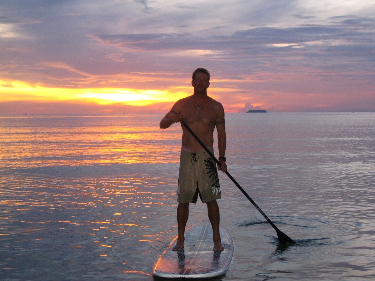A man enjoying paddleboarding on Klong Khong Beach