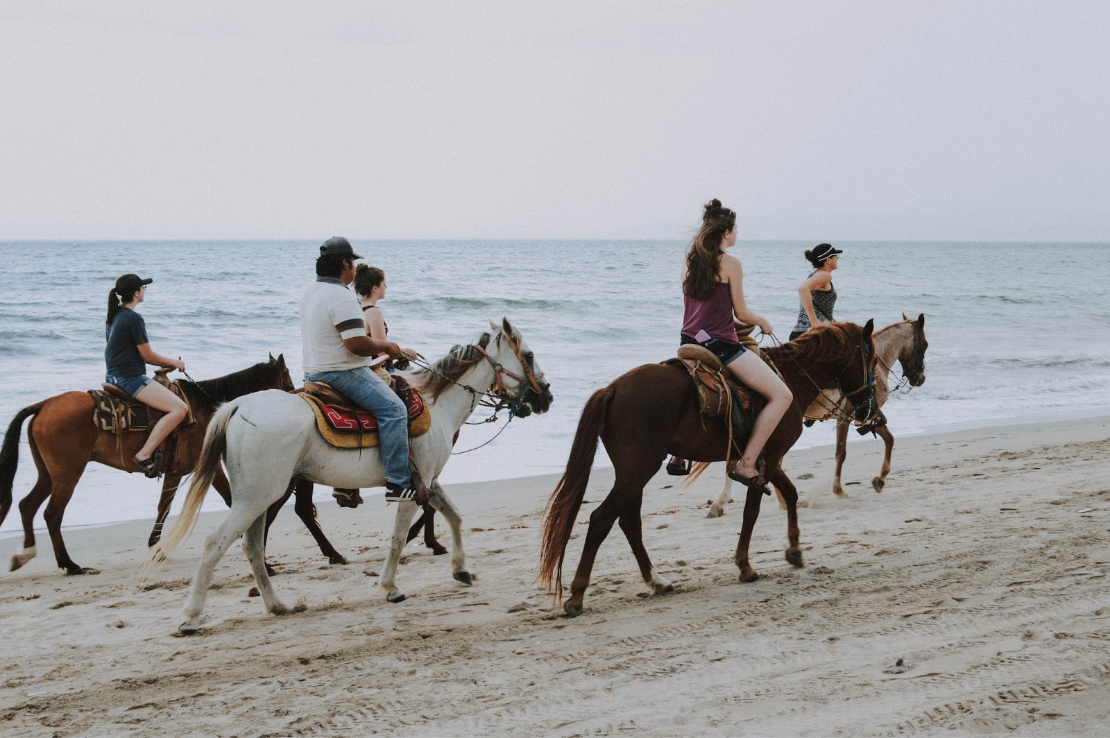 Kids Enjoying Horse Riding At The Beach